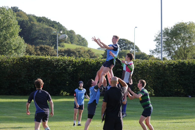 Rugby player being lifted by other players