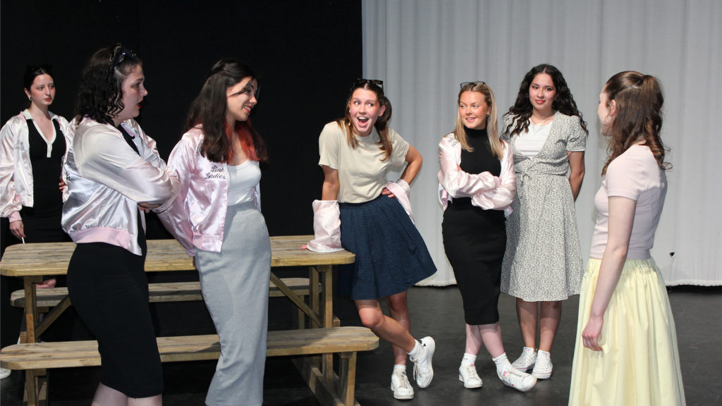 Grease performance 2022 - A group of girls interacting with one another