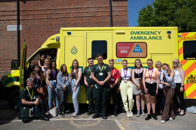 Group of Students standing with paramedics in front of ambulance