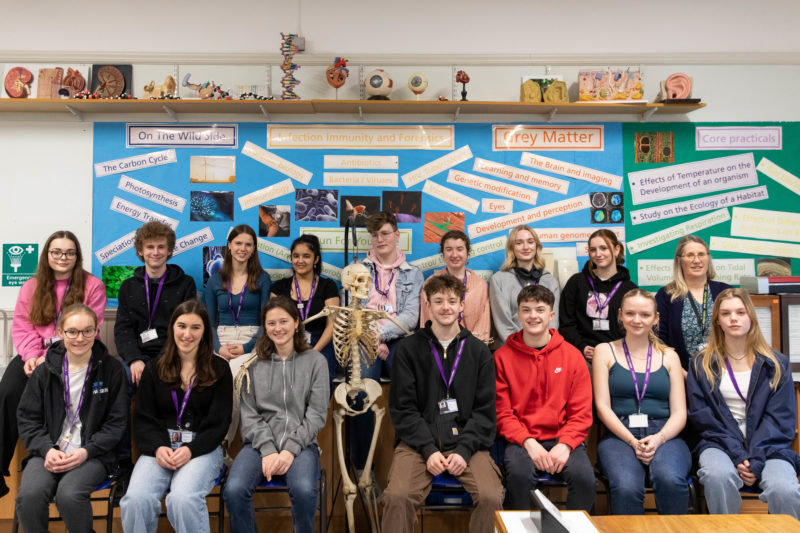 Group photo of students that have received offers featuring the class skeleton in the middle