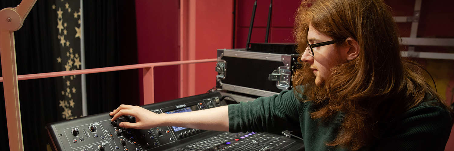 Student working with equipment in a music studio