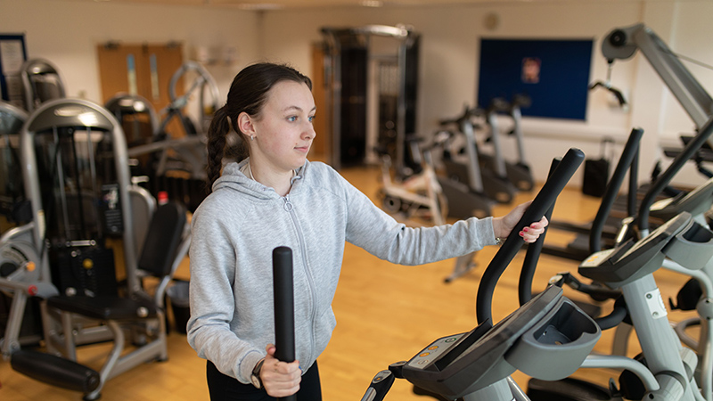 Student exercising in a gym
