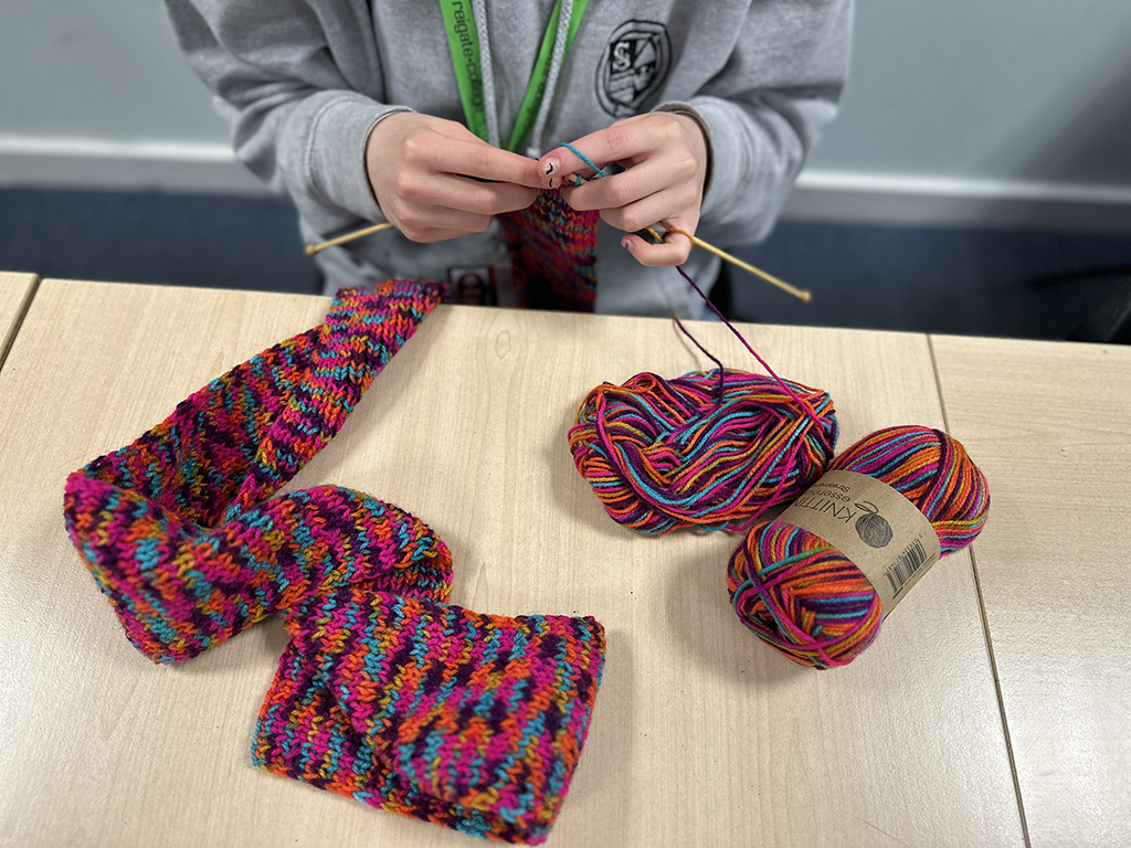 Student knitting with brightly coloured wool