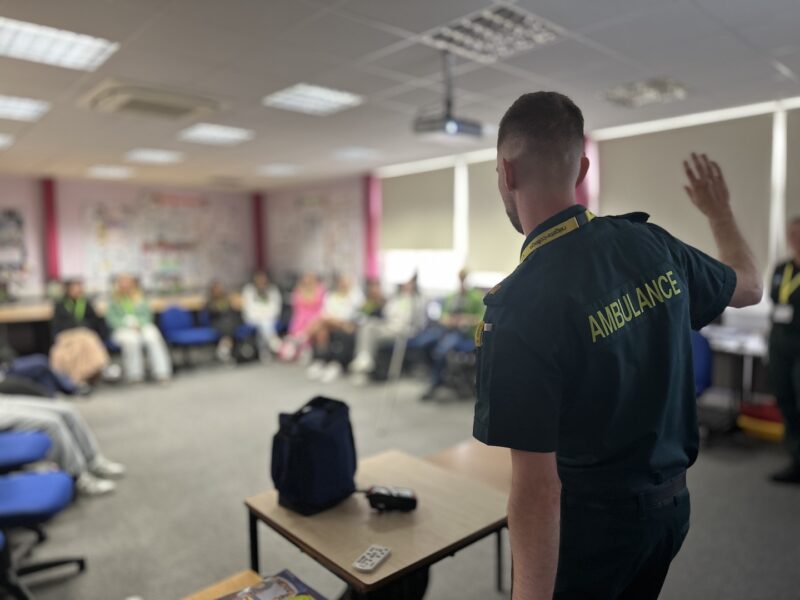 A paramedic presenting to students