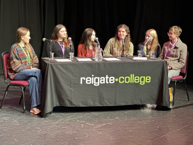 Six members of the speaker panel sitting at a table