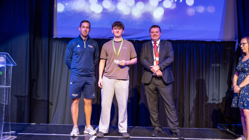 Nick Clarke and Sport Coach with a student smiling for a picture