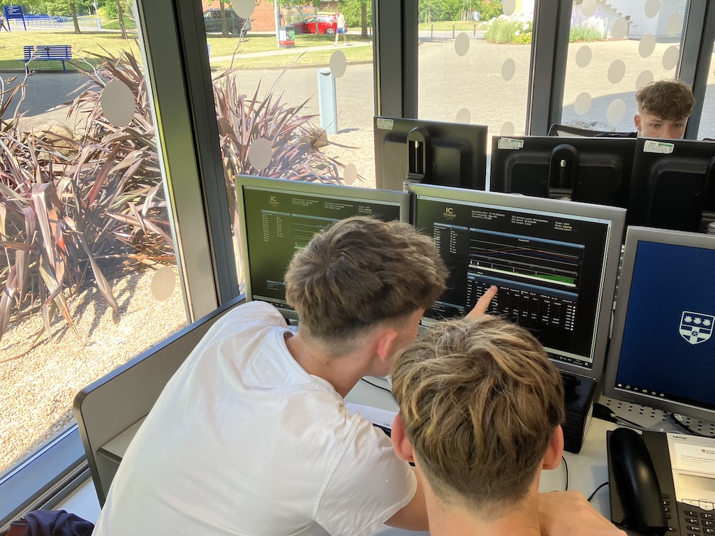 students at the board at June’s Financial Trading trip to the University of Reading