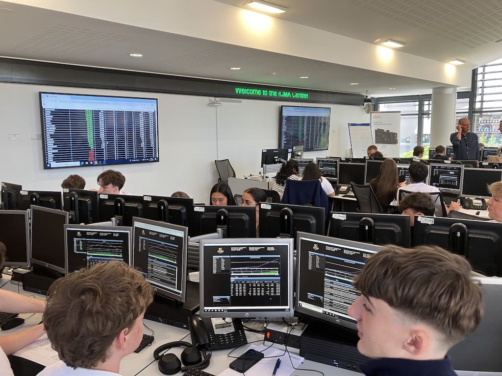 students at the board at June’s Financial Trading trip to the University of Reading