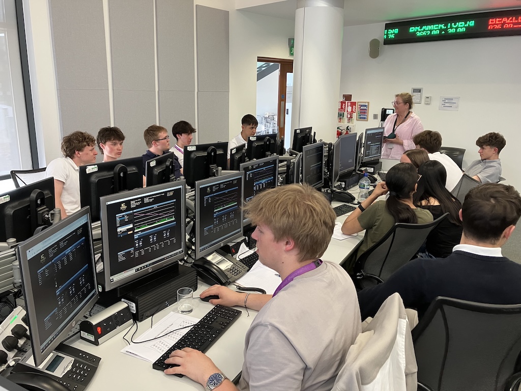 students at the board at June’s Financial Trading trip to the University of Reading