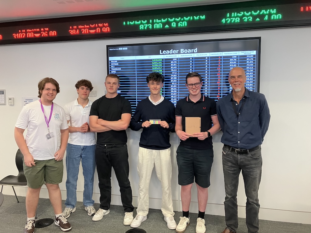 students at the board at June’s Financial Trading trip to the University of Reading