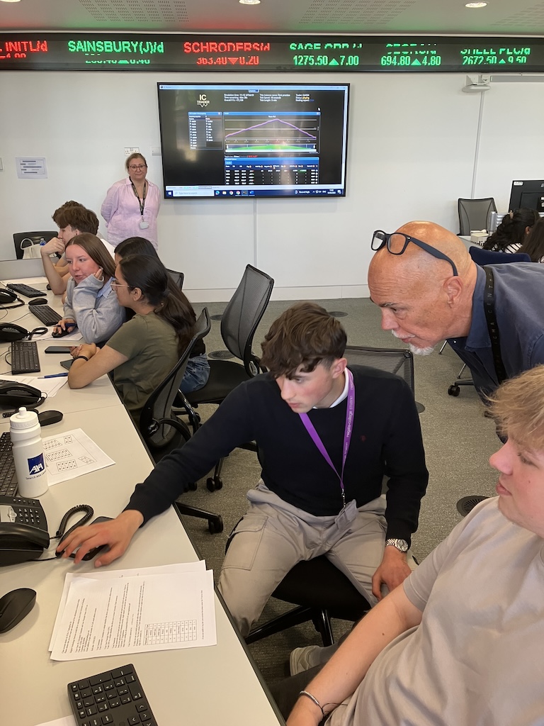 students at the board at June’s Financial Trading trip to the University of Reading