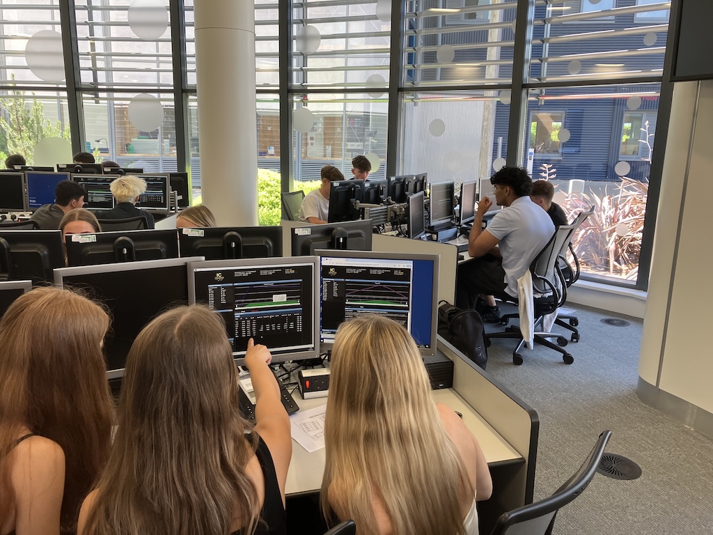 students at the board at June’s Financial Trading trip to the University of Reading
