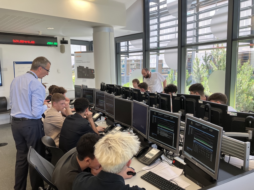 students at the board at June’s Financial Trading trip to the University of Reading