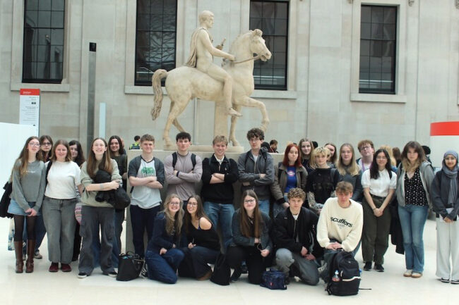 Students in front of a marble statue of a rider on a horse at the British Museum