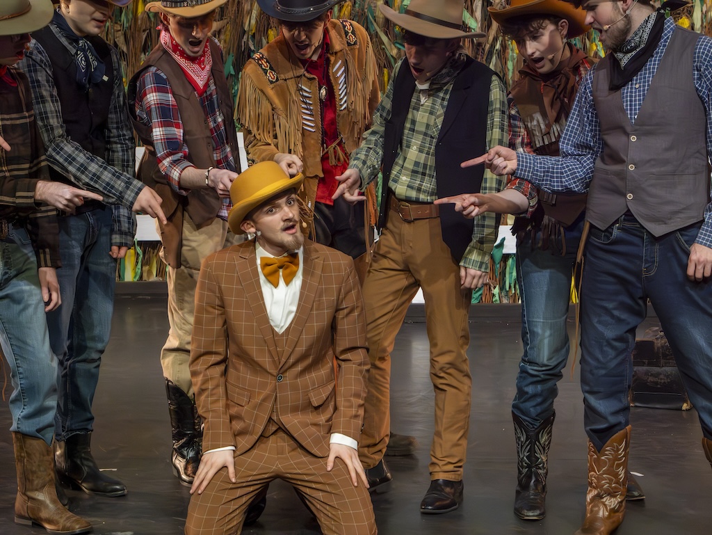 Students performing on stage in the production of Oklahoma - Ali Hakim and cowboys