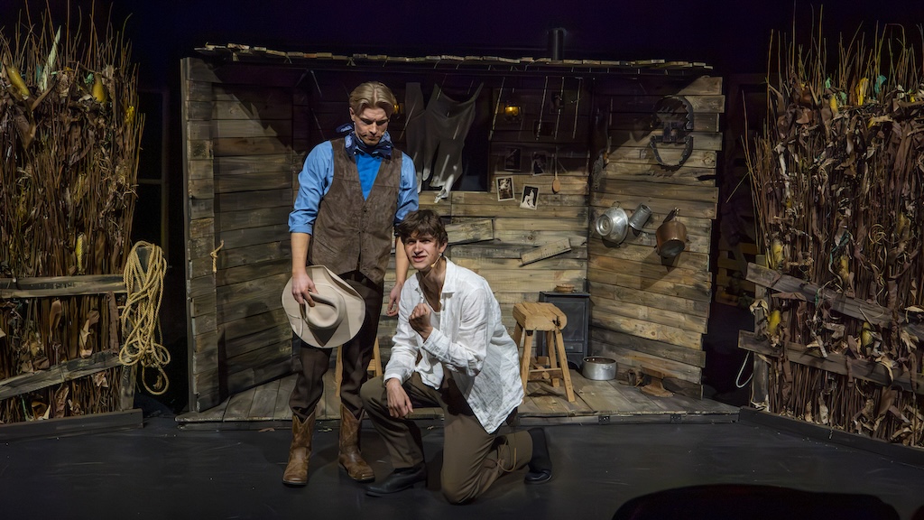 Students performing on stage in the production of Oklahoma - Curly and Jud