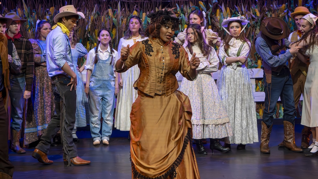 Students performing on stage in the production of Oklahoma - Aunt Eller 