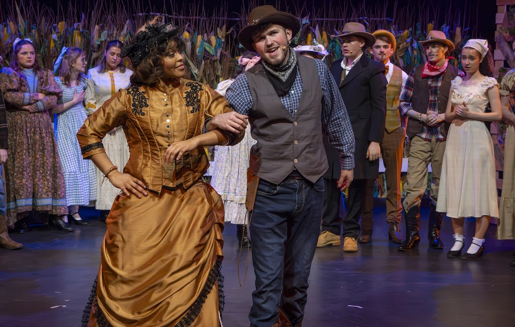 Students performing on stage in the production of Oklahoma