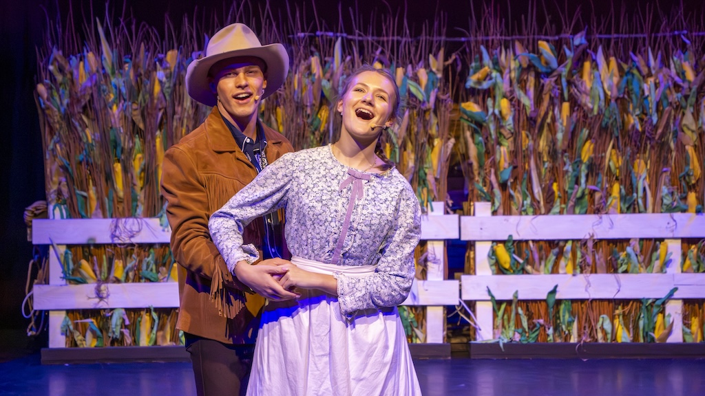 Students performing on stage in the production of Oklahoma - Curley and Laurie