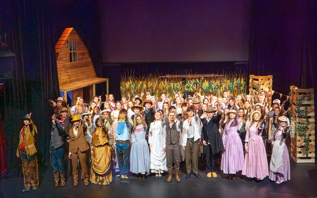 Students performing on stage in the production of Oklahoma - ensemble