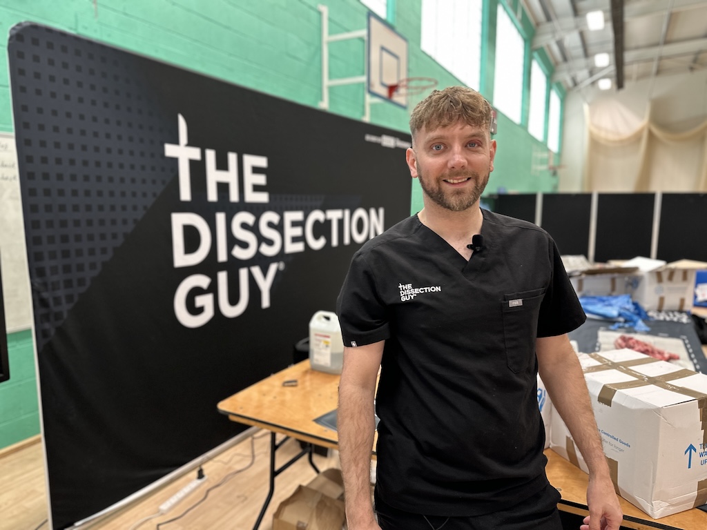 The Dissection Guy posing in front of a display stating "The Dissection Guy"