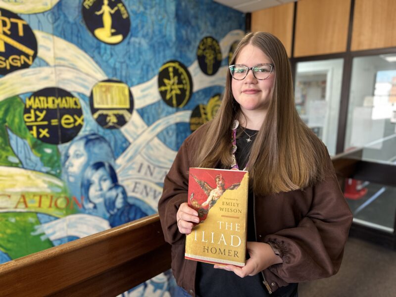 Arlo holding a copy of Homer's The Iliad